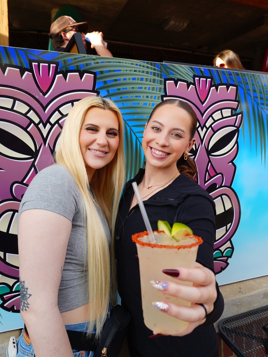A frozen drink in front of the tiki mural at Tipsy Tiki on the Bricktown Canal